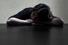 Pensive and sad girl putting her head on the table, horizontal